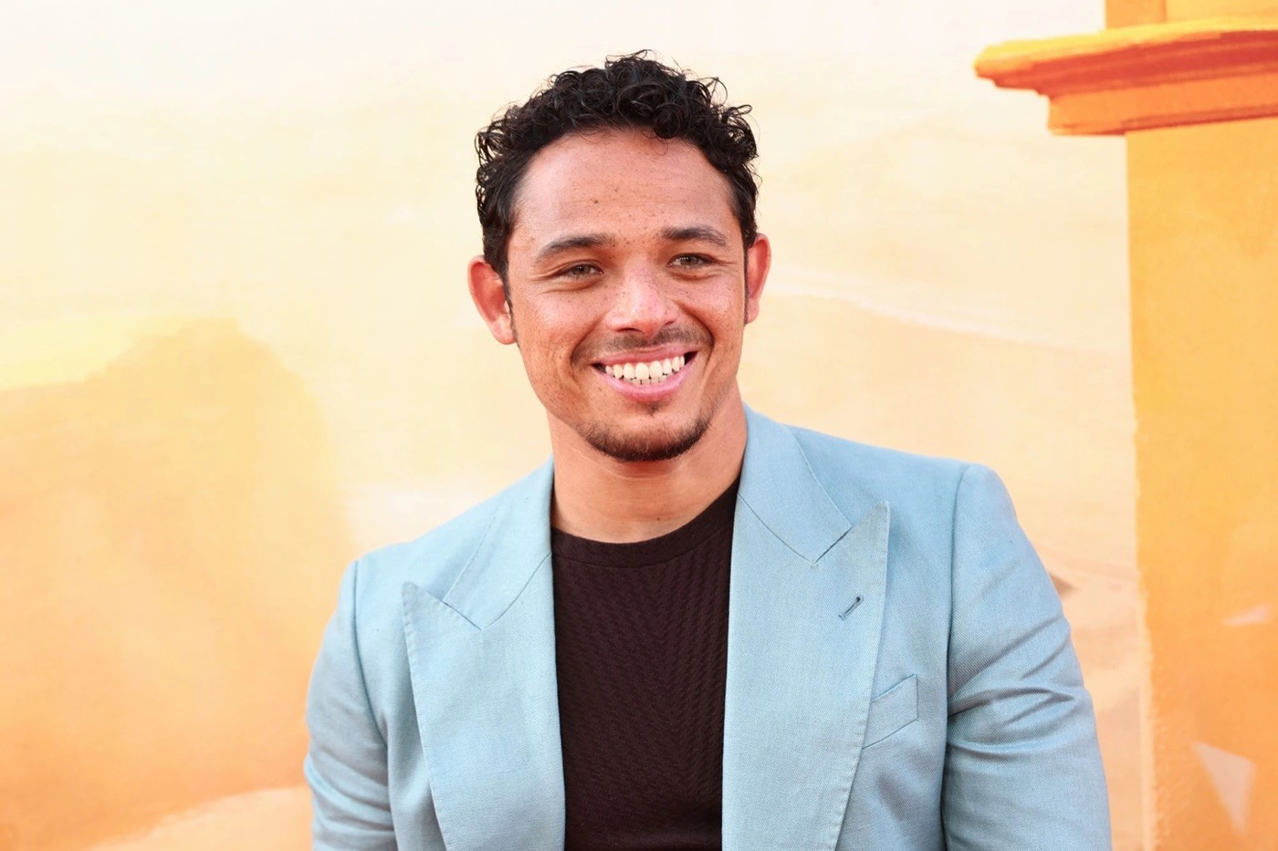 Anthony Ramos smiling in a light blue blazer