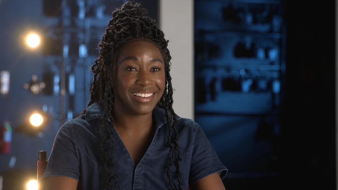 Vasthy Mompoint smiling in a denim top